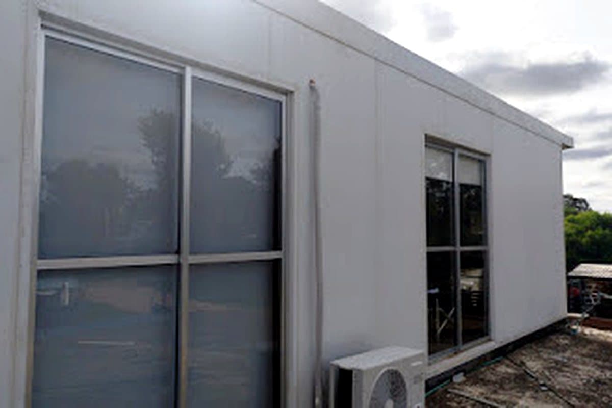 Ampliación con cerramiento exterior blanco y ventanales